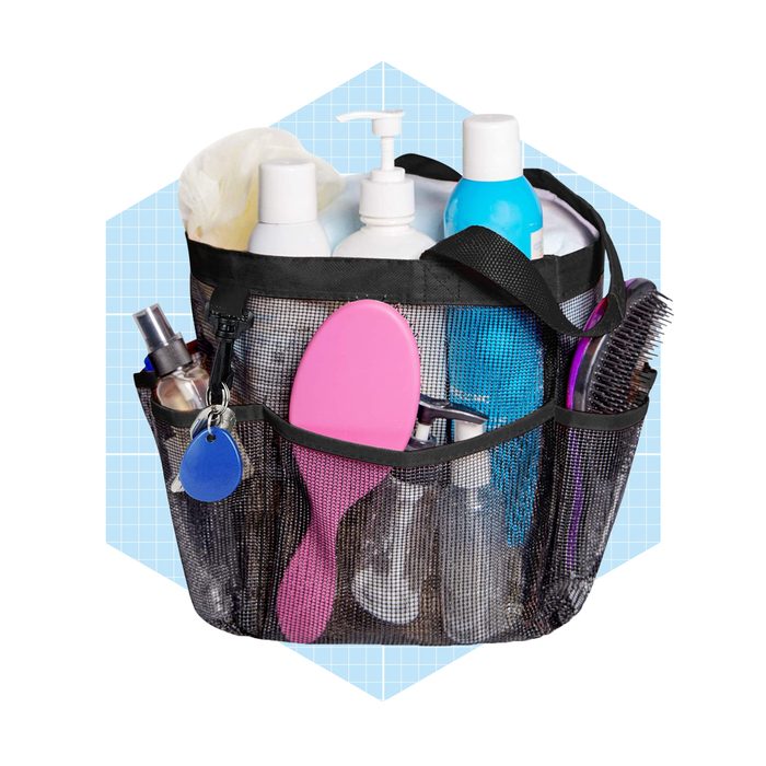 A mesh bag holds various personal care items, including bottles and a pink hairbrush, displayed against a light blue grid background.