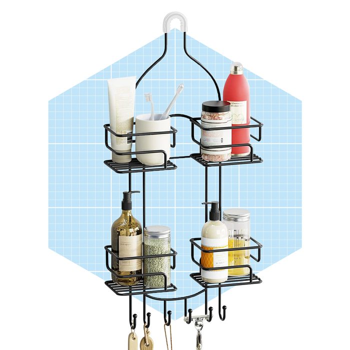 A black metal storage organizer holds various bottles and containers while hanging on a wall against a light blue grid background.