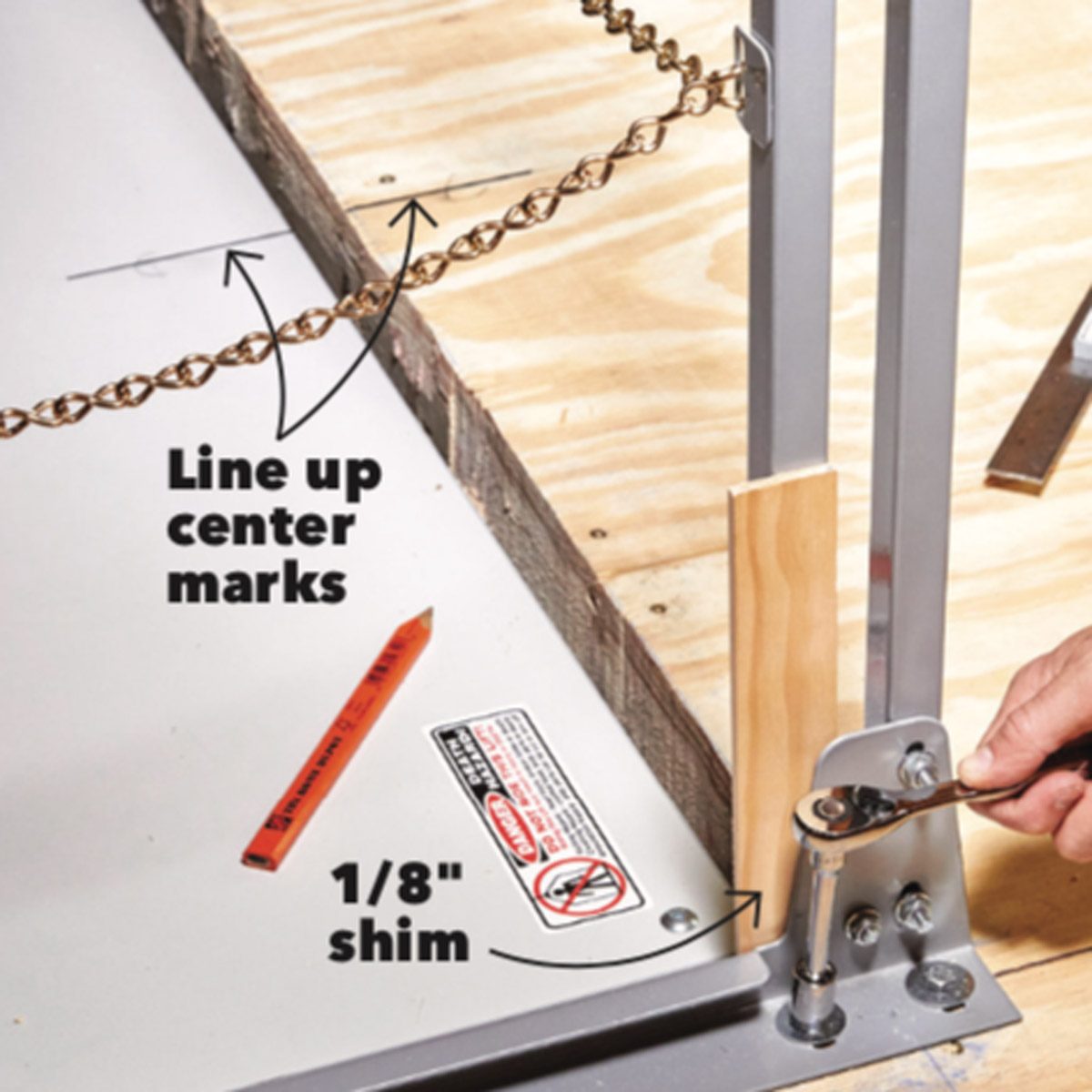 A person adjusts a mechanism using a wrench, positioning a shim next to a chain on a wooden surface, with markings and tools visible nearby.