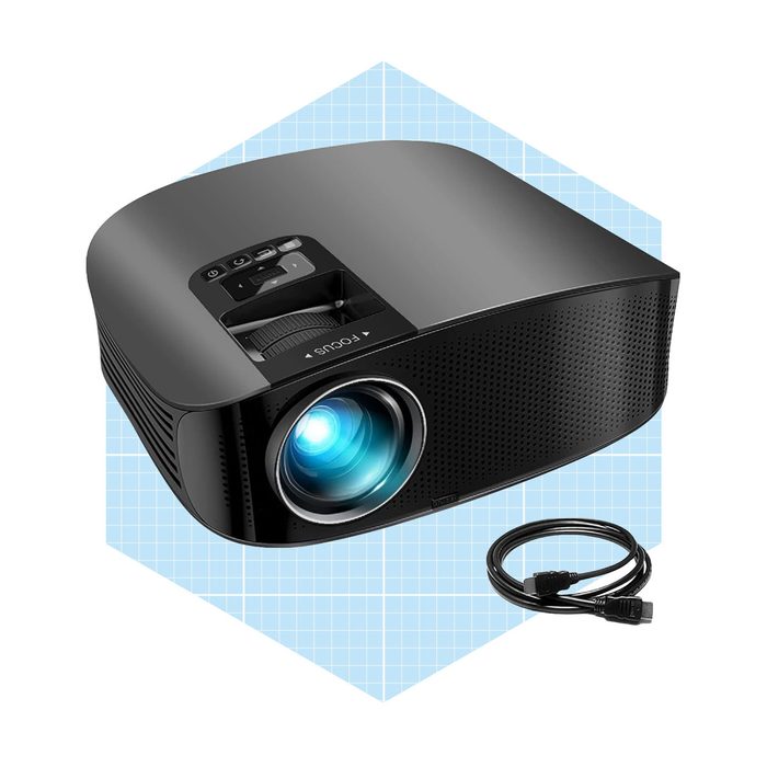 A black projector emits a blue light, positioned against a light blue grid background, accompanied by a connecting cable on the surface beneath it.
