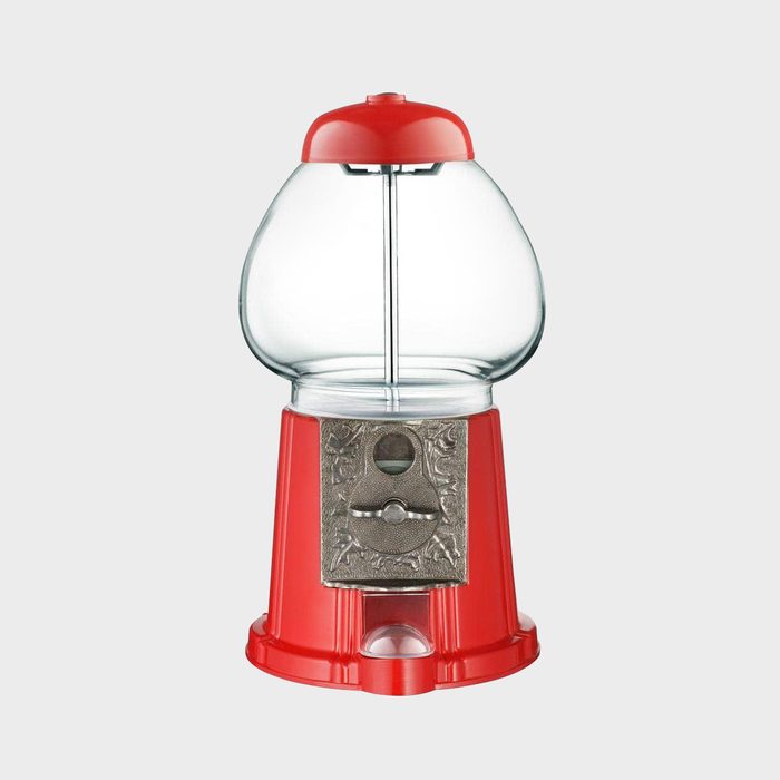 A red gumball machine stands upright, showcasing its clear dome and silver mechanism, ready to dispense candy in a neutral background.