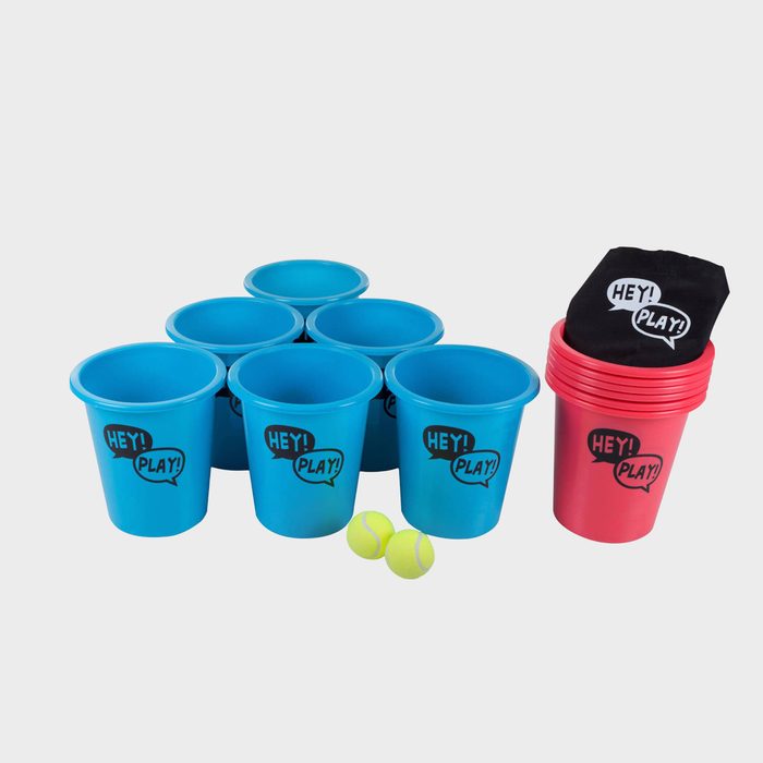 Colorful plastic cups are arranged, with some stacked nearby. Two yellow balls rest on the surface, suggesting a playful setup for a game.