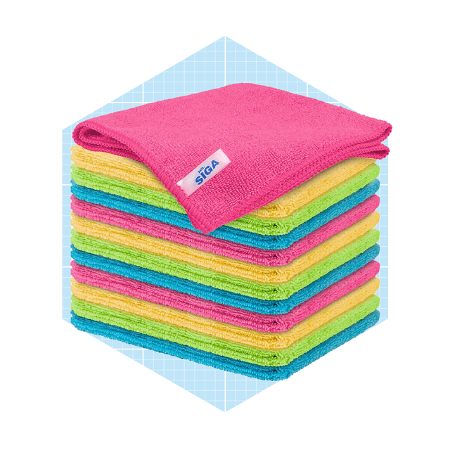 Colorful microfiber towels are neatly stacked, with a top pink towel. The background features a light blue grid pattern, enhancing the organized presentation.