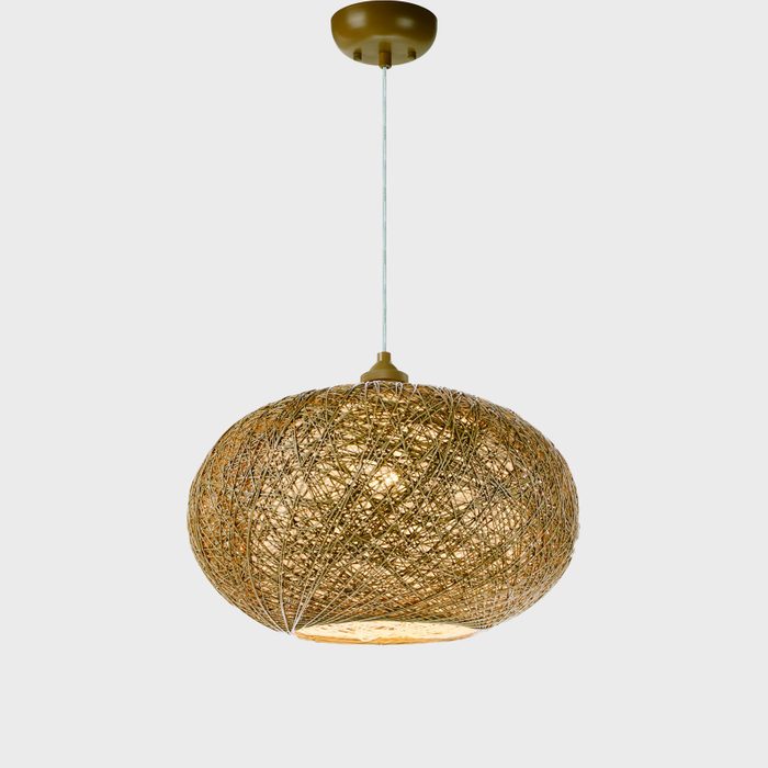 A spherical pendant light made of woven material illuminates a space, suspended from the ceiling by a thin cord against a neutral background.