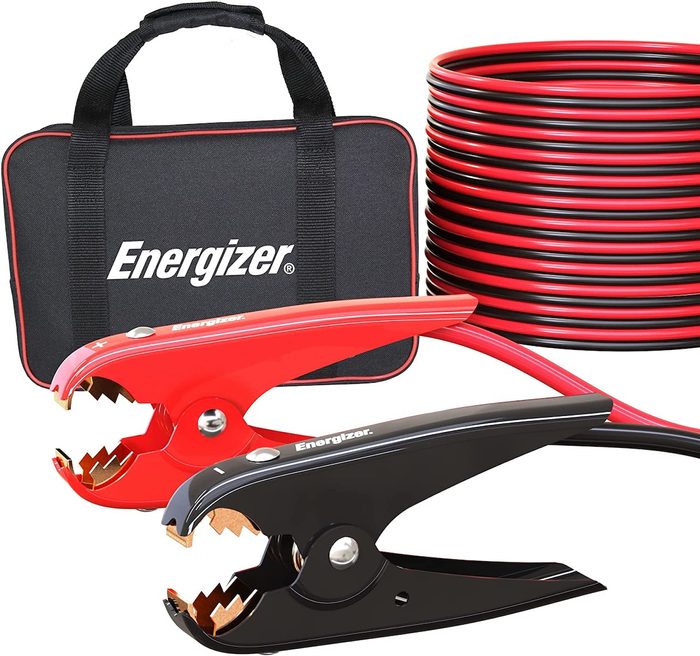 A set of red and black jumper cables lies next to a black storage case labeled 