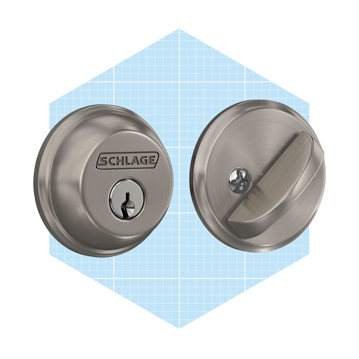 A metallic door lock set features a keyhole and a turn knob, displayed against a light blue grid background, indicating home security.