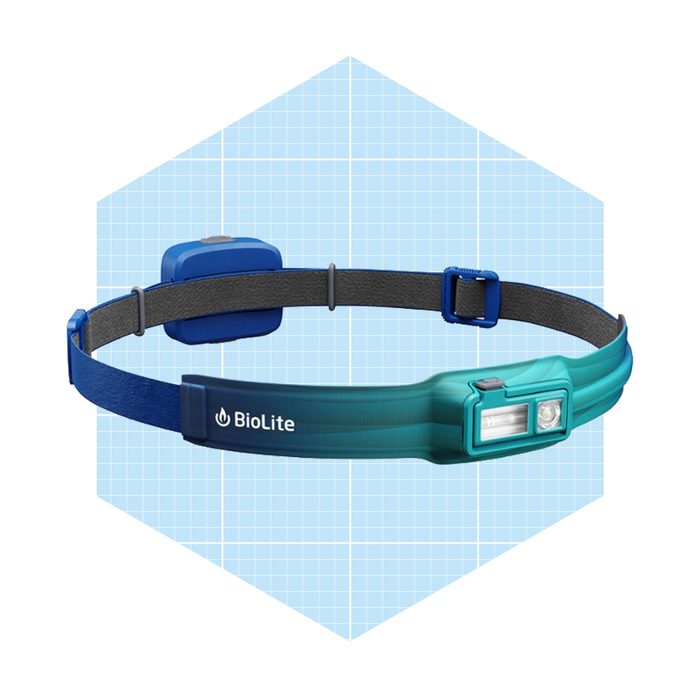 A blue and teal headlamp with an adjustable strap shines light forward, designed for hands-free use in various outdoor or dark settings.