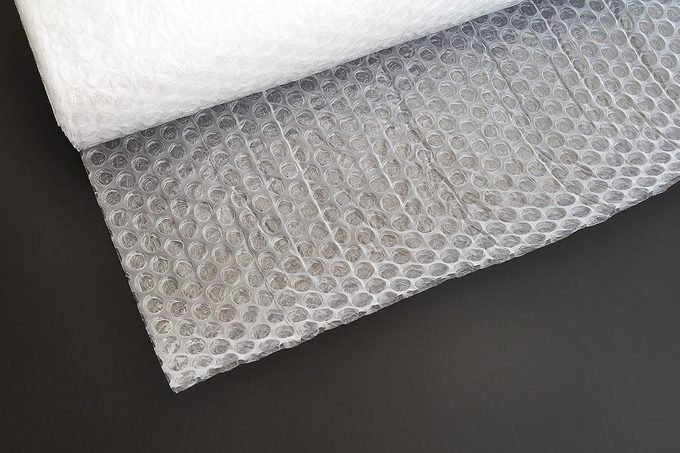 Transparent bubble wrap roll for packaging fragile items on black background